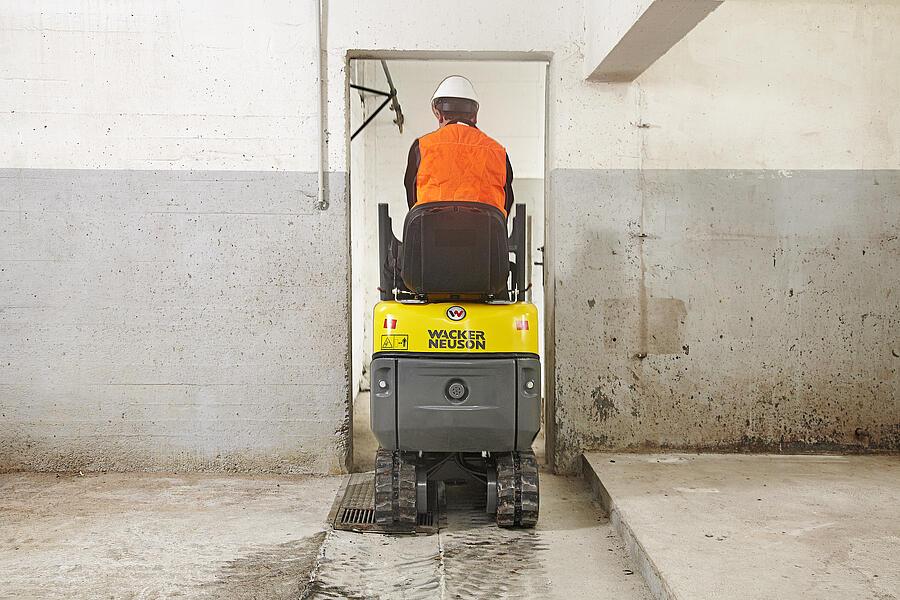 803 mini excavator drives through a narrow entrance