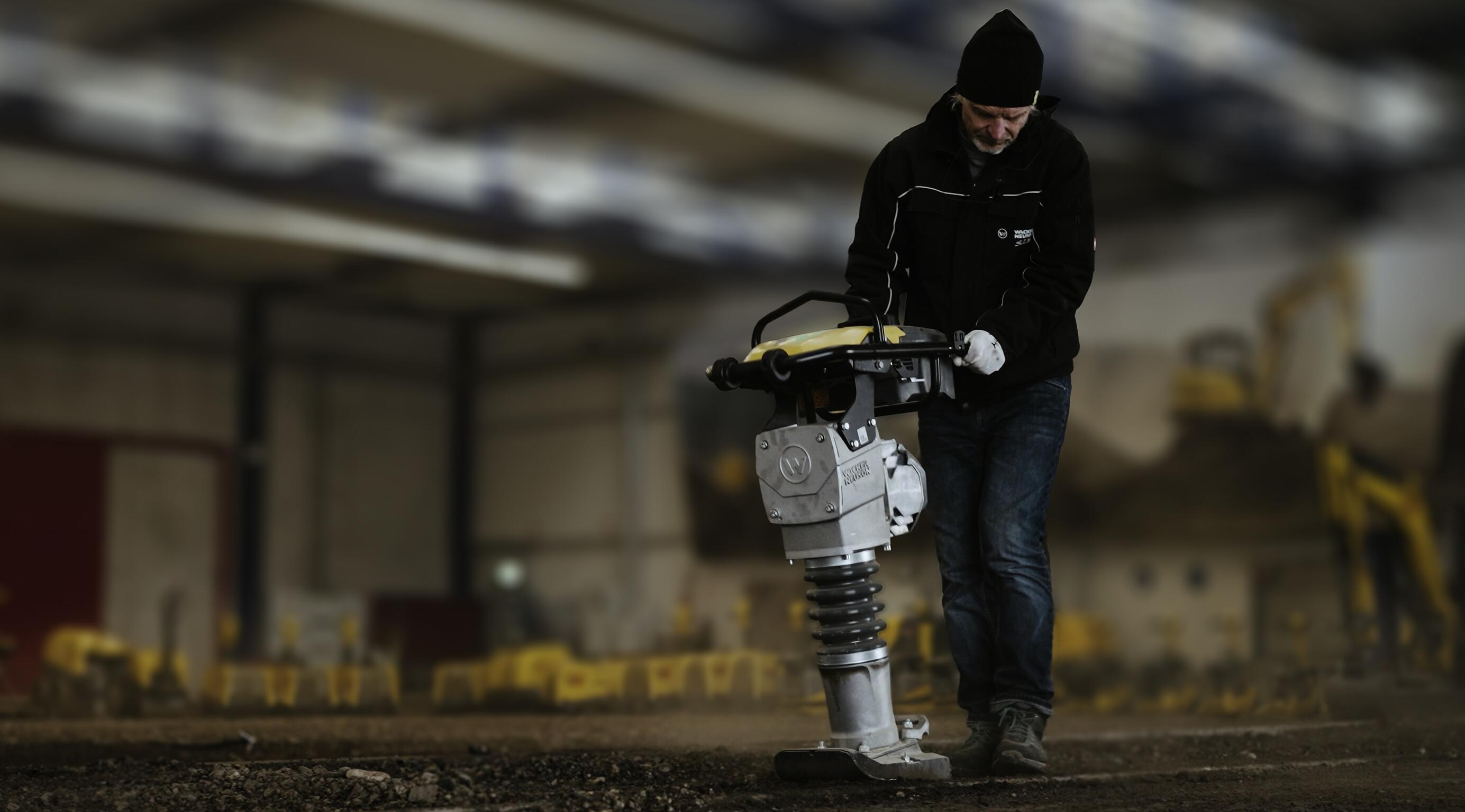 Worker operating rammer for soil compaction in indoor construction training environment