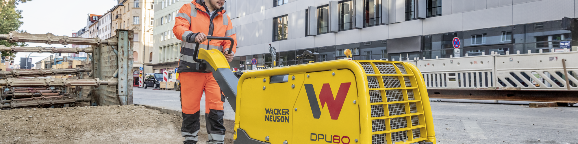 Une plaque vibrante Wacker Neuson en action sur un chantier en ville.