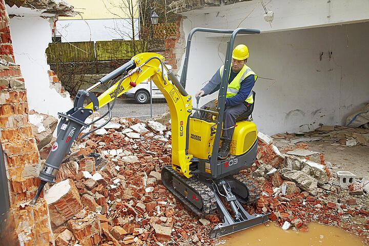 Demolition wirk by means of hydraulic hammer on excavator in action