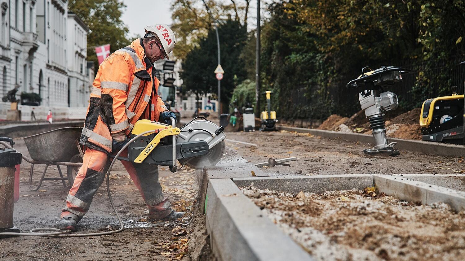 Construction worker working with BTS635s cutting stone