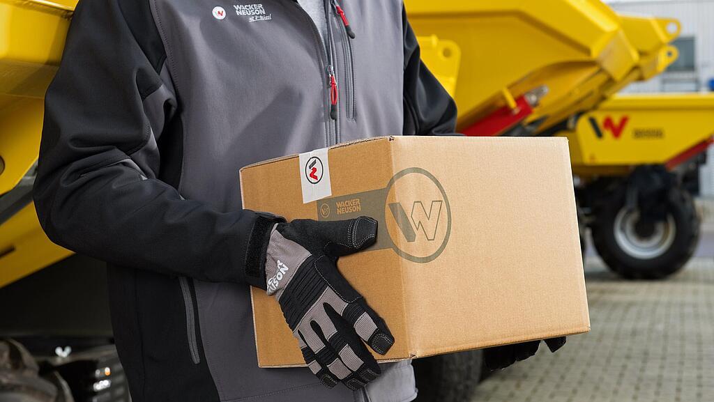 Wacker Neuson employee carrying Wacker Neuson repair package.