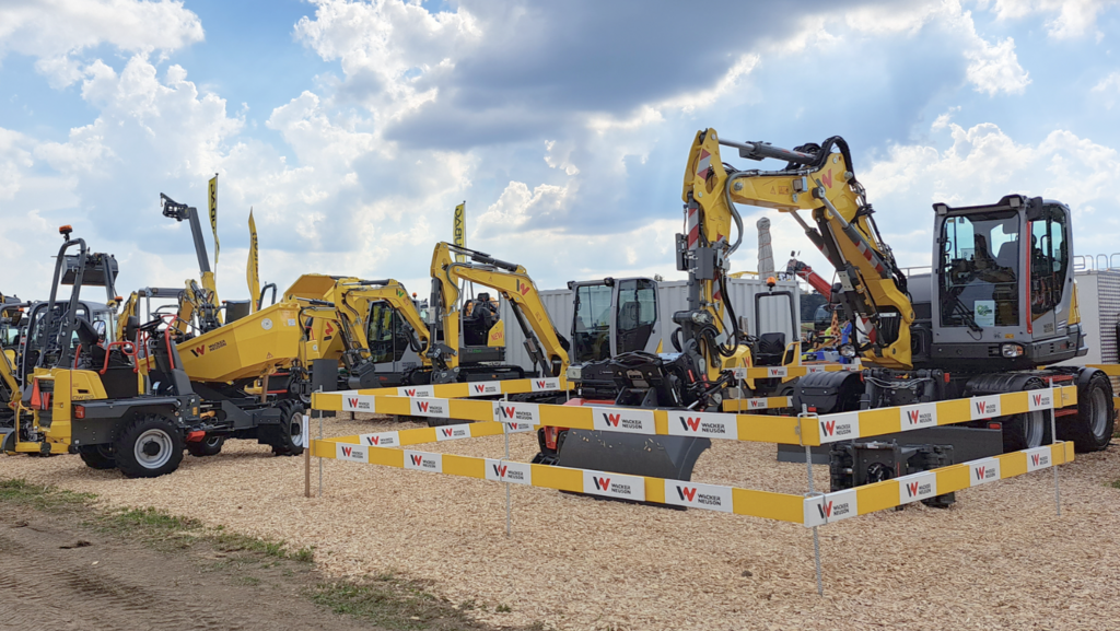 Yellow Wacker Neuson excavators and construction machines at a trade fair booth.