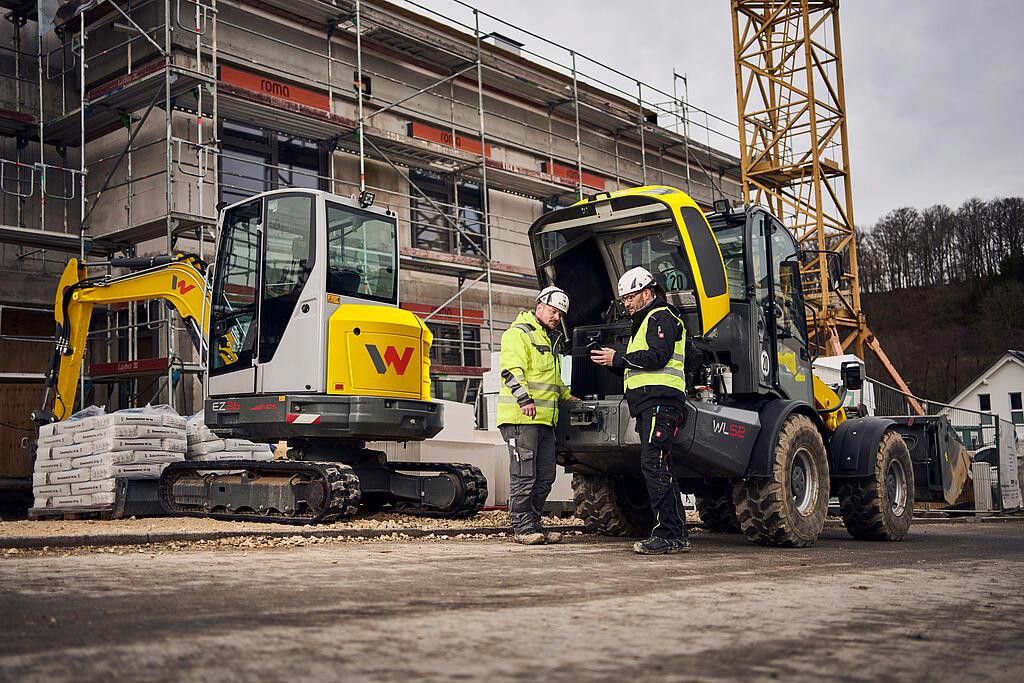 two customers standing in front of wacker neuson machines