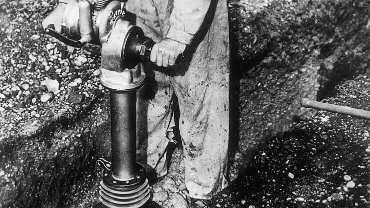 Historic vibratory rammer with combustion engine in application.