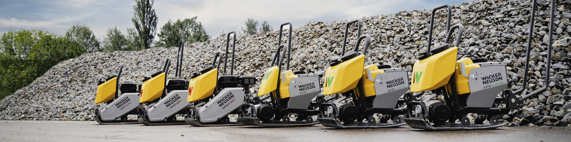 Wacker Neuson APS and BPS vibratory plates beside each other in front of a pile of gravel.