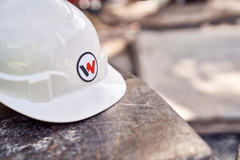 Logo Wacker Neuson na stavební přilbě.