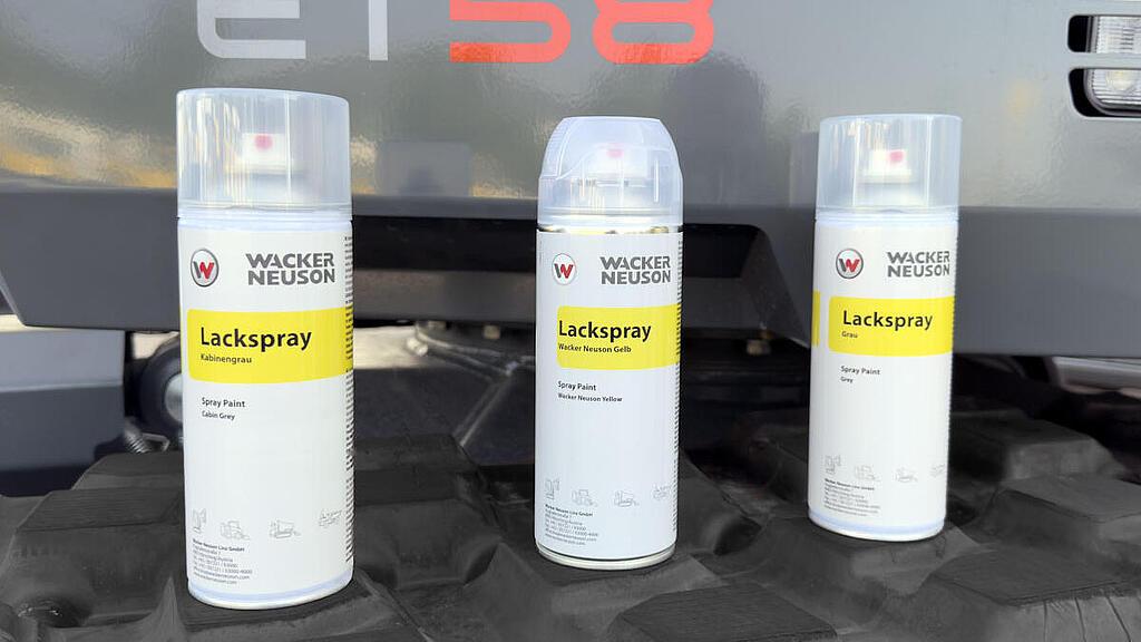 Three Wacker Neuson spray paint cans.