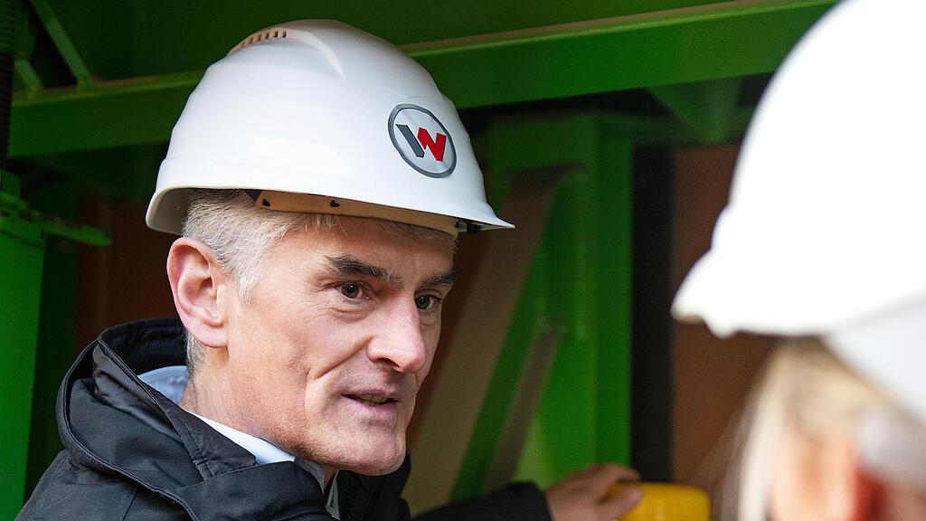 Wacker Neuson employee standing in front of external vibrator and explaining.