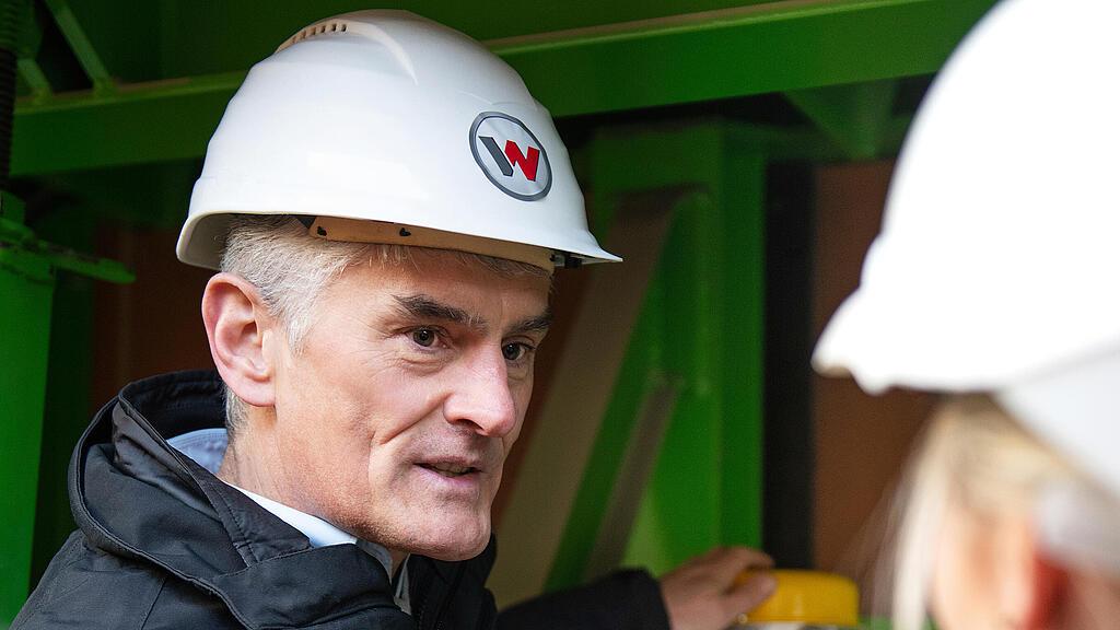 Wacker Neuson employee standing in front of external vibrator and explaining.