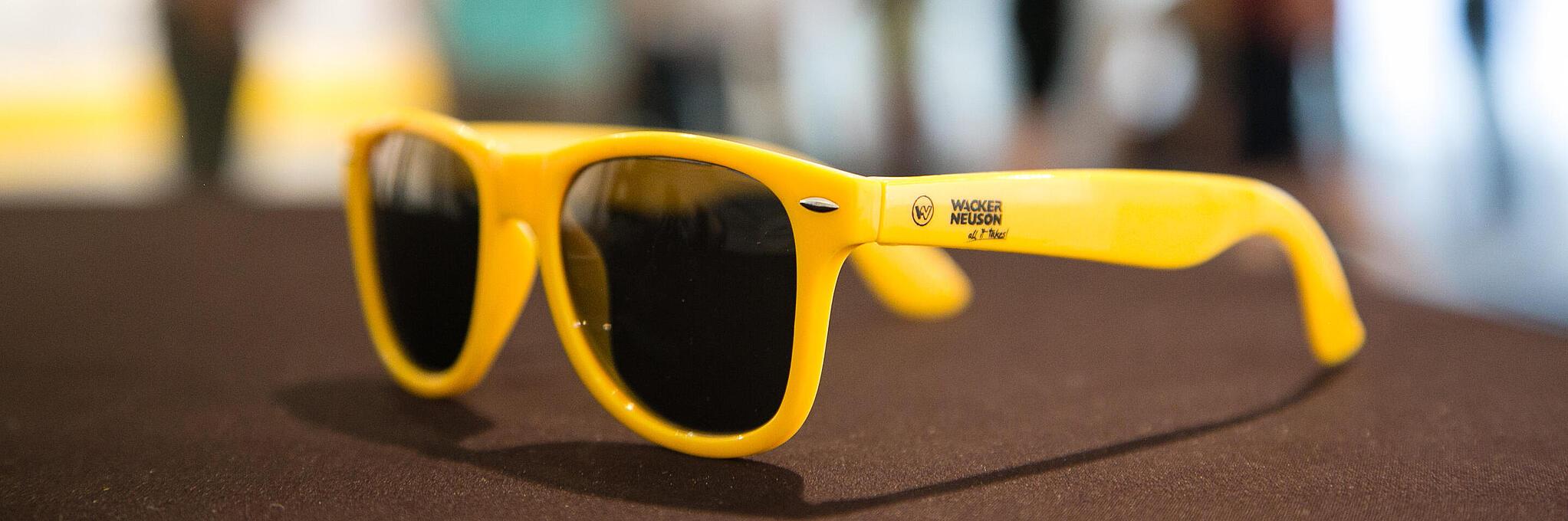 Des lunettes de soleil jaunes portant le logo Wacker Neuson.