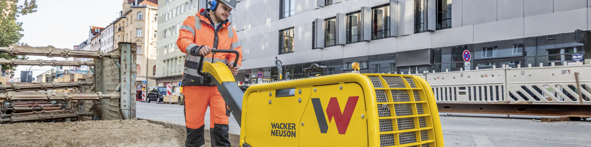 A Wacker Neuson vibratory plate in action on a construction site in the city.
