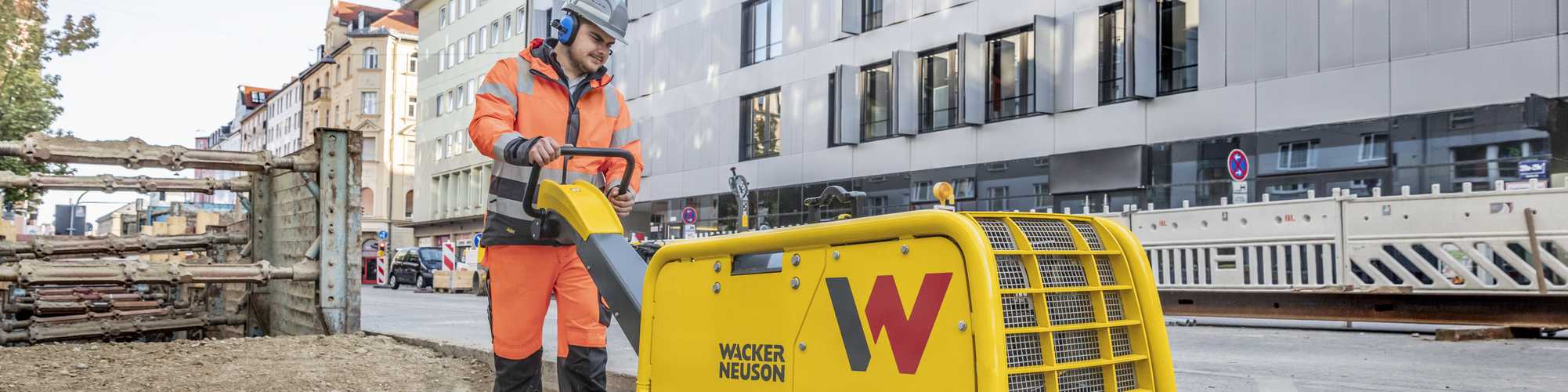 A Wacker Neuson vibratory plate in action on a construction site in the city.