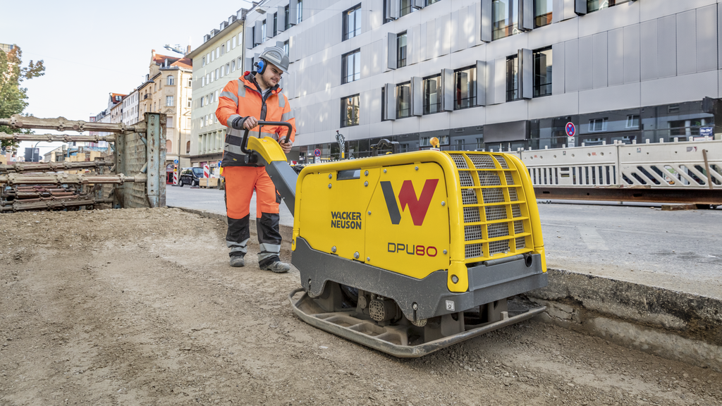Eine Wacker Neuson Vibrationsplatte im Einsatz auf einer Baustelle in der Stadt.