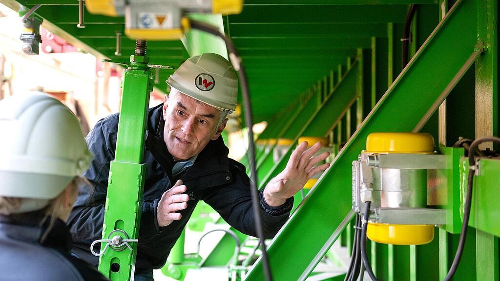 Wacker Neuson employee stands in front of external vibrator, explains it, and also the other Wacker Neuson Concrete Solutions.