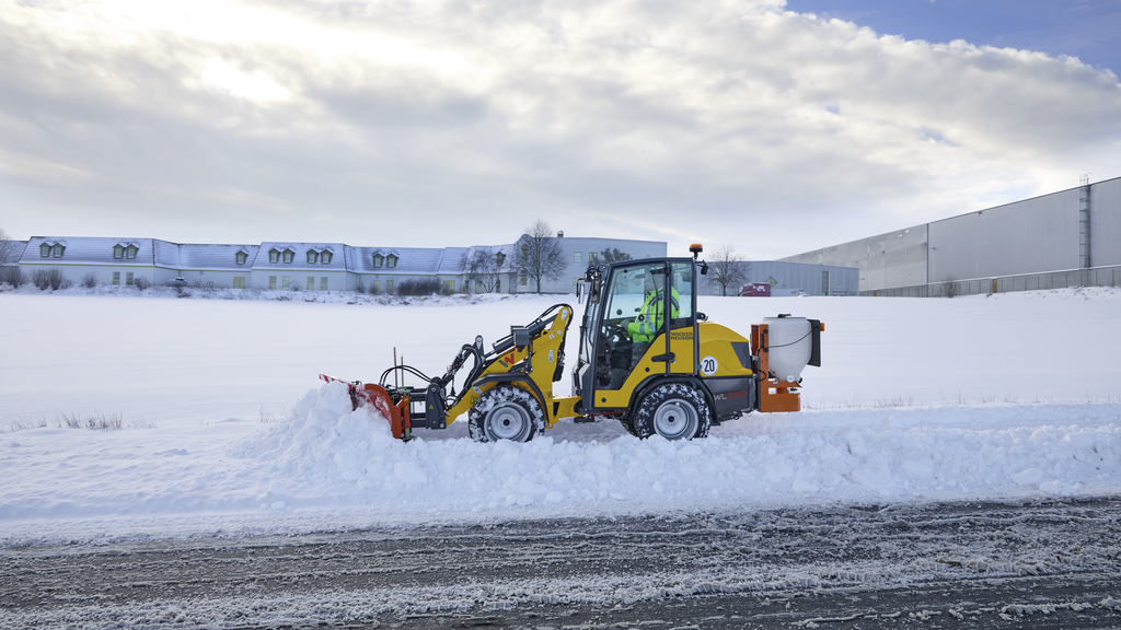 A Wacker Neuson wheel loader clears snow from the roadside.