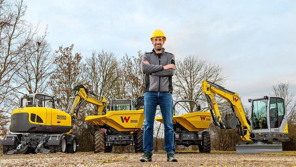 Wacker Neuson customer standing and smiling with arms folded in front of a Wacker Neuson rental park.
