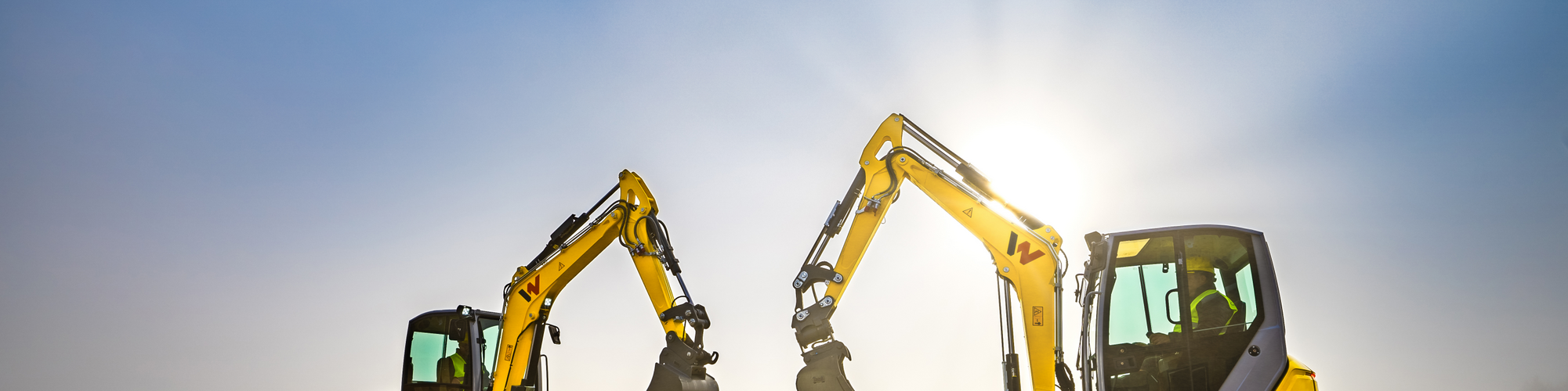 Two Wacker Neuson tracked excavators standing on a construction site.