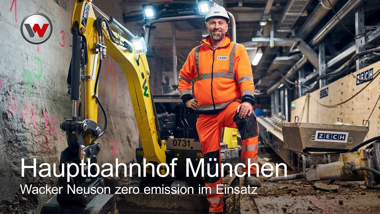 Mann steht neben Stampfer auf Baustelle unter Erde