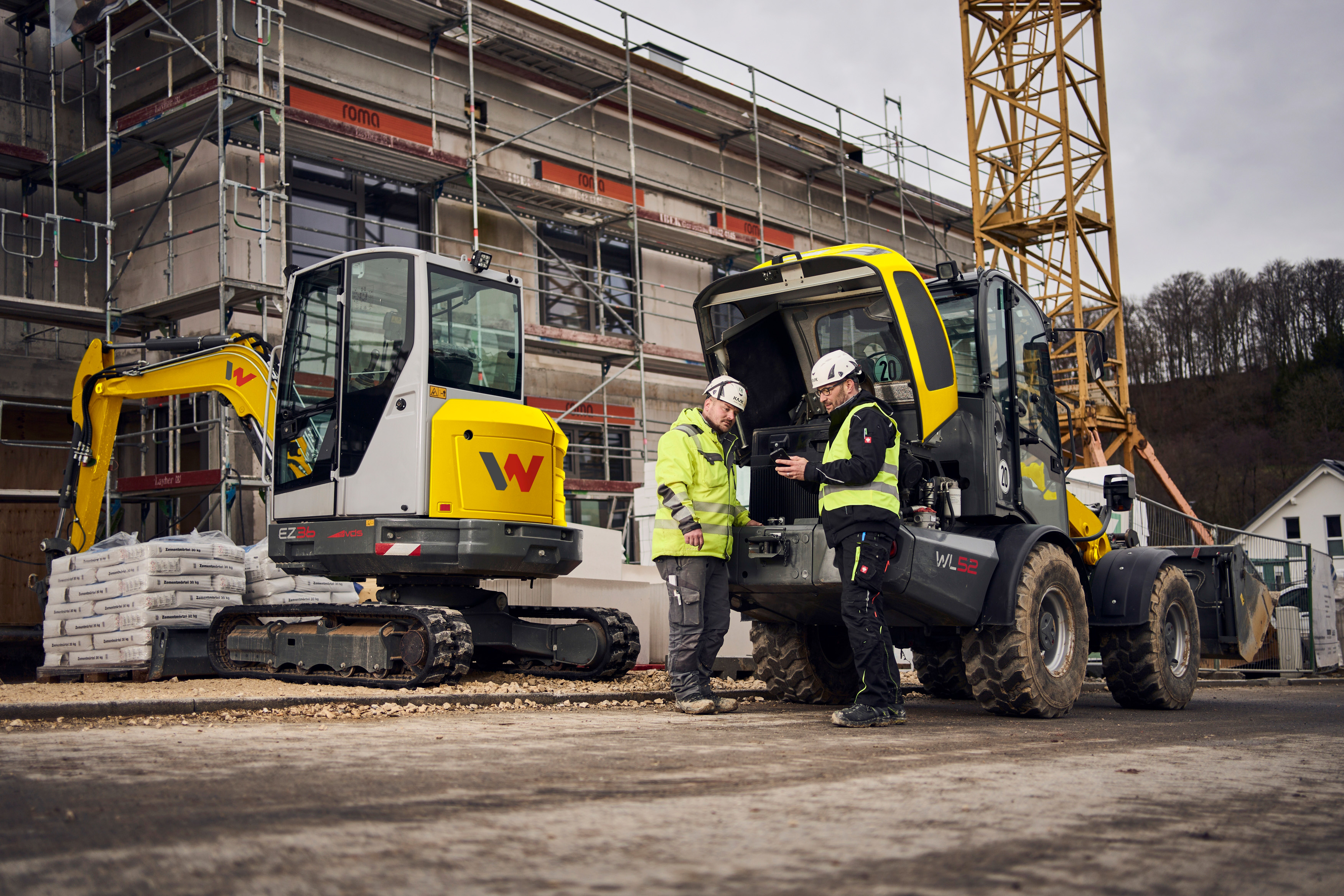 two customers standing in front of wacker neuson machines